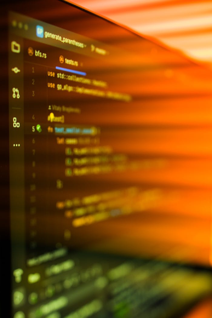 Vibrant, motion-blurred view of programming code on a computer screen with an abstract orange glow.